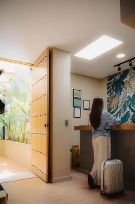 a woman standing at a counter in an office with her luggage at M de oro Apartamentos Muuk boutique POBLADO in Medellín