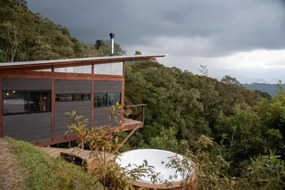a house on the side of a hill with trees at Owl's Watch at Rio Blanco in Manizales