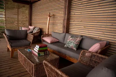 a patio with a couch and chairs and a table at Owl's Watch at Rio Blanco in Manizales