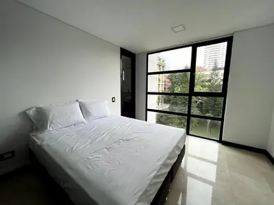 a white bed in a room with a large window at 501 Luxury Apartment In Heart Of El Poblado in Medellín