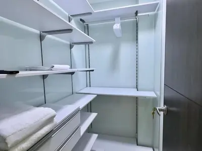 a walk in closet with white shelves and a door at 1401, Luxury Penthouse In El Poblado in Medellín
