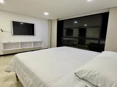 a bedroom with a white bed and a flat screen tv at 1401, Luxury Penthouse In El Poblado in Medellín