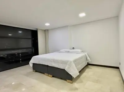 a bedroom with a bed and a flat screen tv at 1401, Luxury Penthouse In El Poblado in Medellín