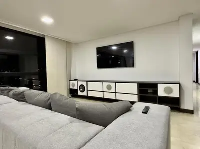 a living room with a couch and a tv on the wall at 1401, Luxury Penthouse In El Poblado in Medellín