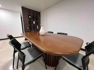 a wooden table with chairs and a vase on it at 802, Amazing apartment in heart of El Poblado + View! in Medellín