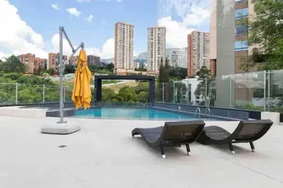 a patio with two chairs and a pool on a building at 802, Amazing apartment in heart of El Poblado + View! in Medellín