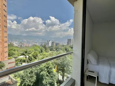 a room with a bed and a view of a city at 802, Amazing apartment in heart of El Poblado + View! in Medellín