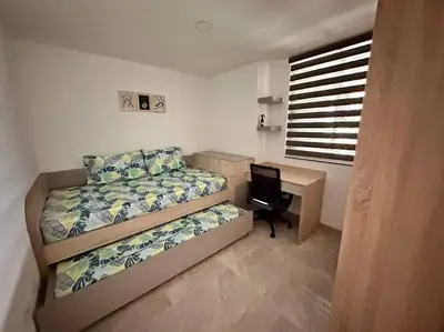 a bedroom with a bed and a desk with a laptop at Aluna Apto/ Wellness and Enjoy in Sabaneta