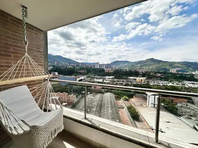 a balcony with a hammock and a view of a city at Aluna Apto/ Wellness and Enjoy in Sabaneta