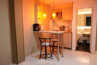 a small kitchen with two bar stools and a counter at Provenza Medellin Hotel Boutique in Medellín