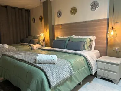 a bedroom with two beds with green and white sheets at Provenza Medellin Hotel Boutique in Medellín