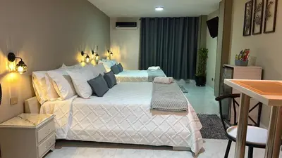 a bedroom with a large bed and a desk at Provenza Medellin Hotel Boutique in Medellín