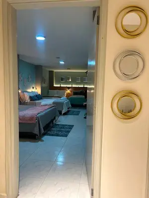 a hallway to a bedroom with two beds and a living room at Provenza Medellin Hotel Boutique in Medellín