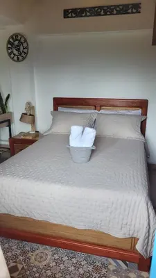 a bed with two pillows and a basket on it at Apartamento Corona in Confines