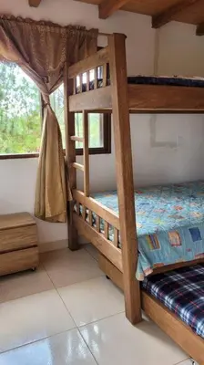 a bedroom with two bunk beds and a window at Luz de Luna - Hermosa Finca Familiar con Vista Panorámica y de Aves in Cocorná