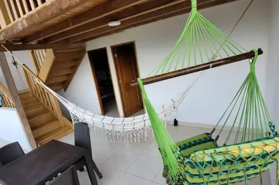 a hammock in the living room of a house at Luz de Luna - Hermosa Finca Familiar con Vista Panorámica y de Aves in Cocorná
