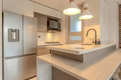a kitchen with a stainless steel refrigerator and a counter at San Telmo Lake Guatape view in Guatapé