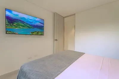 a bedroom with a bed with a tv on the wall at San Telmo Lake Guatape view in Guatapé