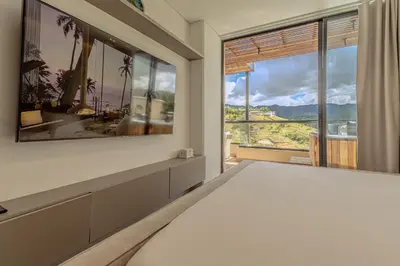 a bedroom with a bed and a large window at San Telmo Lake Guatape view in Guatapé