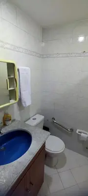 a bathroom with a toilet and a blue sink at Familiar y acogedor in Medellín