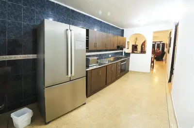 a kitchen with a stainless steel refrigerator and brown cabinets at Familiar y acogedor in Medellín