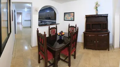 a dining room with a table and a kitchen at Familiar y acogedor in Medellín