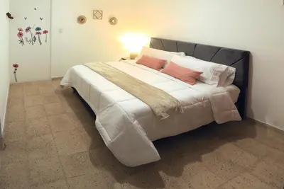 a bedroom with a large bed with pink pillows at Familiar y acogedor in Medellín