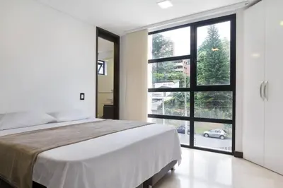 a bedroom with a large bed and a large window at 301 Modern space in exclusive area of El Poblado in Medellín