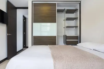 a bedroom with a white bed and a closet at 301 Modern space in exclusive area of El Poblado in Medellín