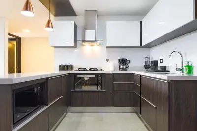 a kitchen with wooden cabinets and white appliances at 301 Modern space in exclusive area of El Poblado in Medellín