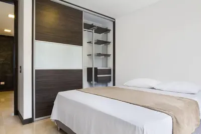 a bedroom with a white bed and a closet at 301 Modern space in exclusive area of El Poblado in Medellín
