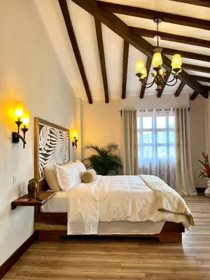 a bedroom with a large white bed with a chandelier at WR Boutique Hotel in Jardin