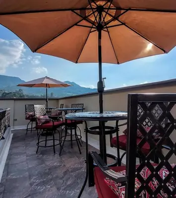 a patio with tables and chairs and an umbrella at WR Boutique Hotel in Jardin
