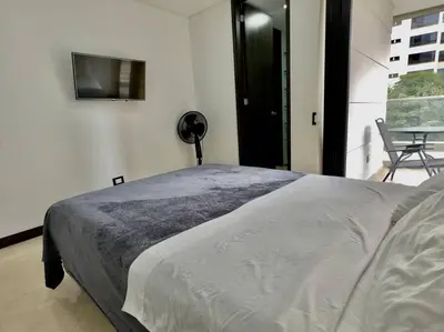 a bedroom with a bed and a tv on the wall at 502 El Poblado: Beautiful & ample space for families in Medellín