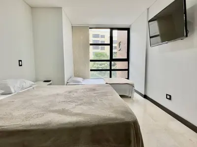 a bedroom with two beds and a flat screen tv at 502 El Poblado: Beautiful & ample space for families in Medellín
