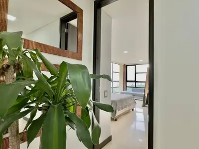 a living room with a potted plant and a mirror at 502 El Poblado: Beautiful & ample space for families in Medellín