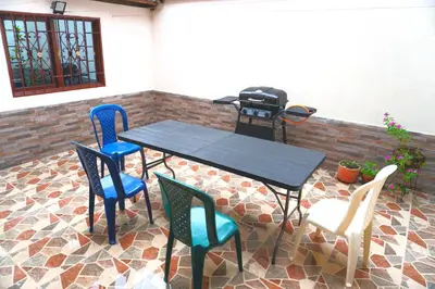 a table and chairs with a grill on a patio at Confortable casa tradicional in San Carlos
