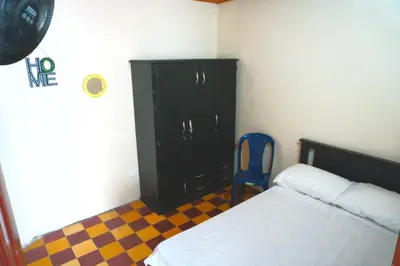 a bedroom with a black cabinet and a blue chair at Confortable casa tradicional in San Carlos