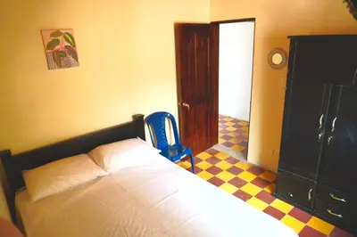 a bedroom with a bed and a blue chair at Confortable casa tradicional in San Carlos