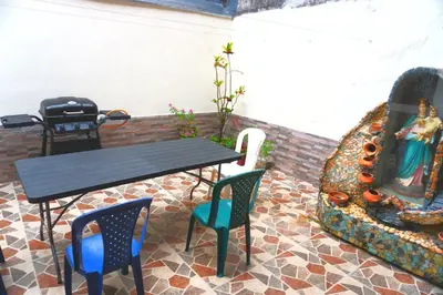 a table and chairs next to a large fireplace at Confortable casa tradicional in San Carlos