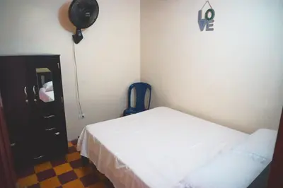a small bedroom with a bed and a dresser and a room at Confortable casa tradicional in San Carlos