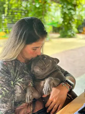 a woman holding a dog in her arms at Hotel Chicala salgar in Puerto Salgar