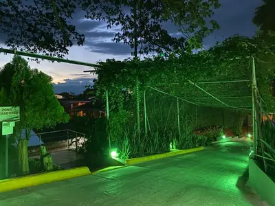 an empty parking lot at night with green lights at Hotel Chicala salgar in Puerto Salgar