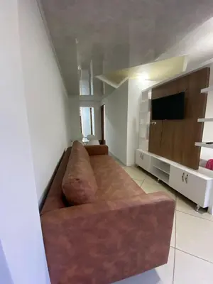 a living room with a brown couch and a television at Laurel Dorado apartotel in Medellín