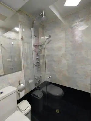 a bathroom with a toilet and a glass shower at Laurel Dorado apartotel in Medellín