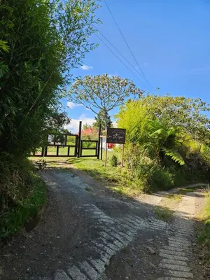 a dirt road with a sign next to a fence at Casa De Campo 