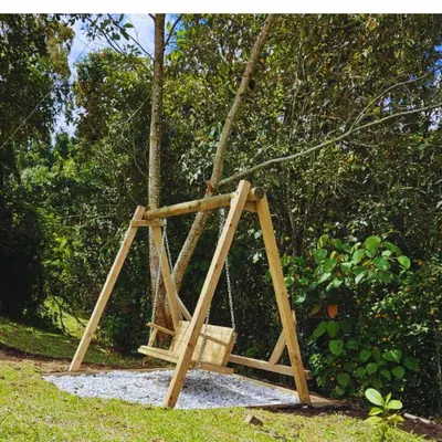a wooden swing set with a basket in the grass at Casa De Campo 