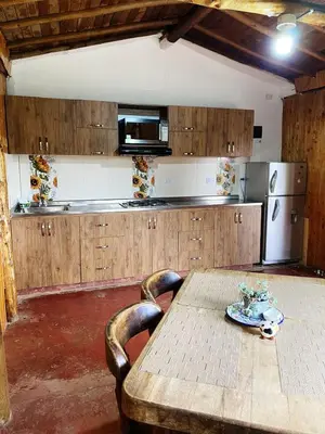 a kitchen with a wooden table and a refrigerator at Casa De Campo 