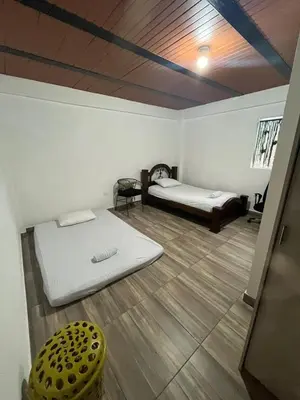 a room with two beds and a yellow stool at Las 5 Quintas - Acogedora casa in San Rafael