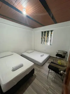 a room with two beds and a table in it at Las 5 Quintas - Acogedora casa in San Rafael